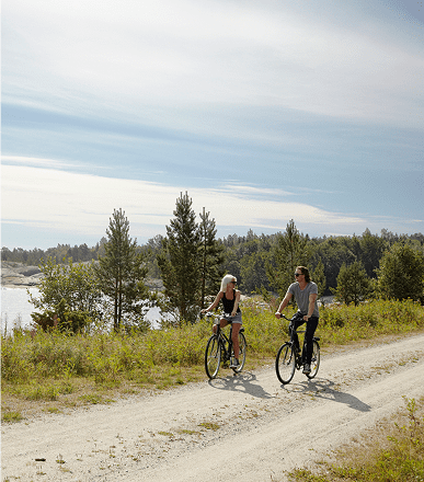 Two people cycling on a dirt path.